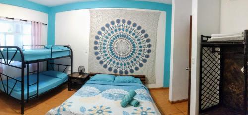 a bedroom with a bunk bed and blue walls at Cool Vibes Beach Hostel in Dominical
