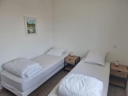 deux lits dans une chambre aux murs blancs dans l'établissement Maison pour 6p - 3ch - piscine privée - au calme, à Argelès-sur-Mer