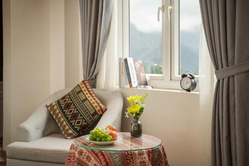 a living room with a table with a bowl of fruit at Sapa Praha Hotel in Sa Pa
