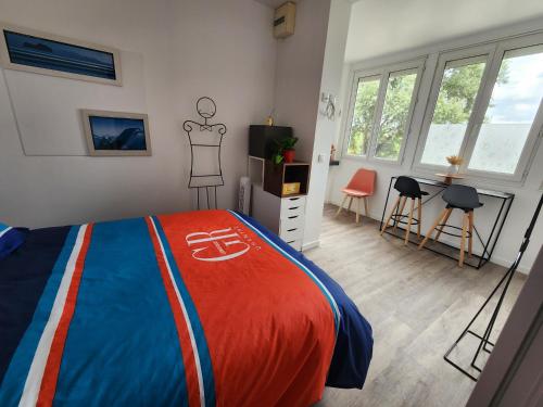 a bedroom with a bed with a red and blue blanket at Les Pingouins de la Marne 2 in Le Perreux-Sur-Marne