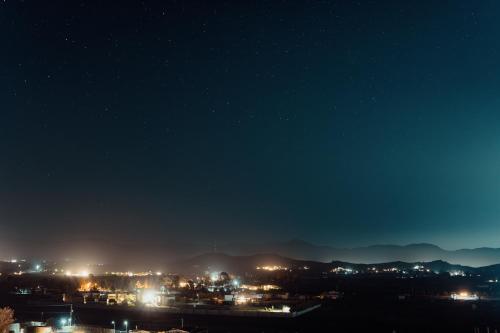 a view of a city at night with lights at Bajo Estrellas Hotel Contemporáneo in Valle de Guadalupe