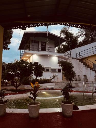 a house with a swimming pool in front of a building at Hundar Hills Eco Farm Stay in Thūr