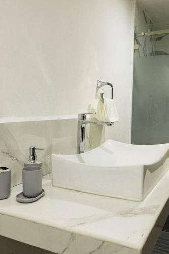 a white bathroom sink with a lamp on a counter at Lujosa casa en el Bosque cerca de la ciudad in San Cristóbal de Las Casas