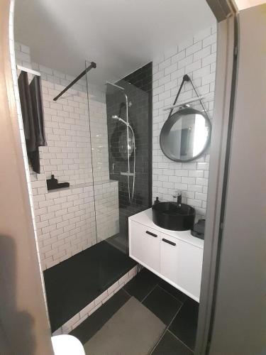 une salle de bain blanche avec un lavabo et une douche dans l'établissement Appartement terrasse Vendée Globe, à Les Sables-dʼOlonne