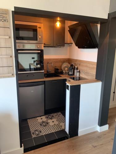 Il comprend une petite cuisine dotée de carrelage noir et blanc. dans l'établissement Appartement terrasse Vendée Globe, à Les Sables-dʼOlonne