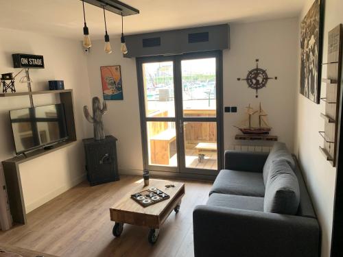 un salon avec un canapé et une table dans l'établissement Appartement terrasse Vendée Globe, à Les Sables-dʼOlonne