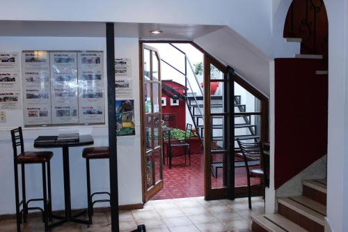 a room with a staircase and a table and chairs at Hostel Lagares in Mendoza