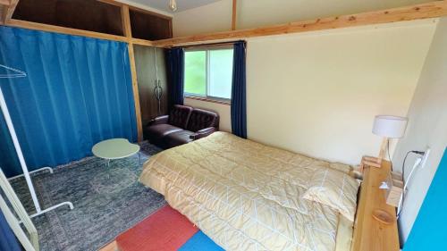 a bedroom with a bed and a chair and a window at SLOW HOUSEkesennuma 102,103 - Vacation STAY 72219v in Kesennuma