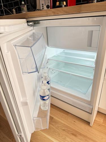 - un réfrigérateur ouvert avec une bouteille d'eau dans l'établissement Chez Zenovia, à Paris