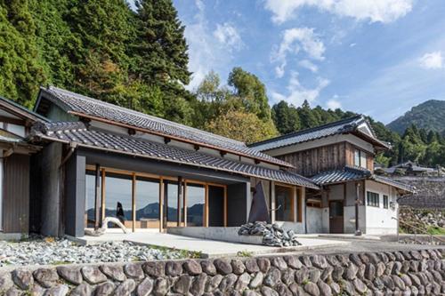 a house with a stone wall in front of it at glaminka KAMIKAWA - Vacation STAY 73980v in Kamikawa