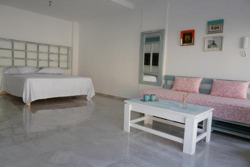 Una sala de estar con una cama, un sofá y una mesa. en Le grand horizon, en Sfax