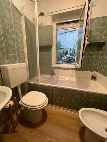 Un baño con inodoro, bañera y lavabo. en La casa alle Calandre, en Ventimiglia