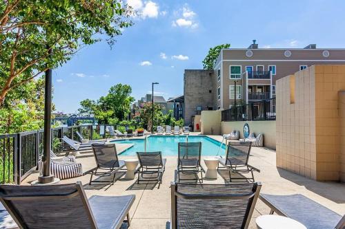 a patio with chairs and a swimming pool at Downtown Nashville Riverfront Condo in Nashville