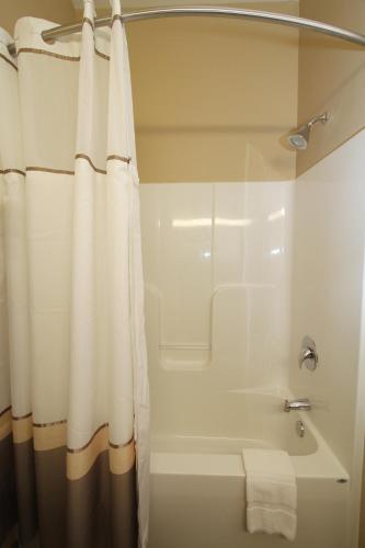 a bathroom with a tub and a shower with a shower curtain at Bowman Lodge & Convention Center in Bowman
