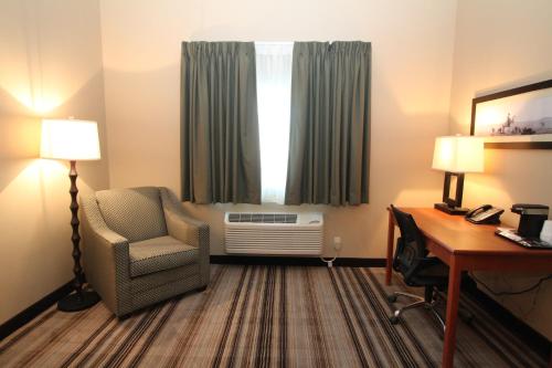 a hotel room with a desk and a chair and a window at Bowman Lodge & Convention Center in Bowman