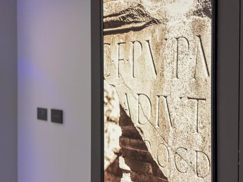 a framed picture of a sign on a wall with the words dear karma at Teatro Romano Exclusive Suites in Trieste