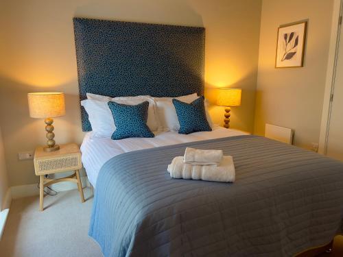 a bedroom with a large bed with blue pillows at Lambert House in Harrogate