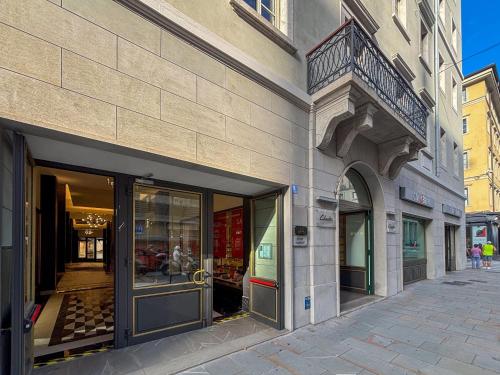 a building with glass doors on a street at Teatro Romano Exclusive Suites in Trieste
