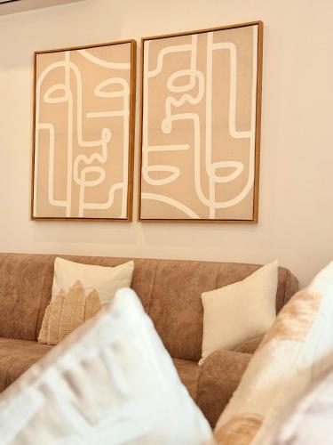 two framed pictures on the wall above a couch at The Apparte Salalah in Ţāqah