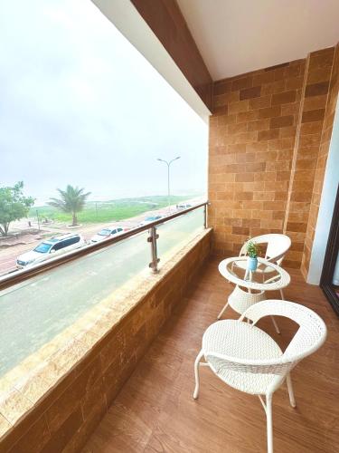 a balcony with two chairs and a view of the ocean at The Apparte Salalah in Ţāqah