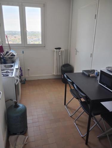 - une cuisine avec une table et une table ainsi que 2 fenêtres dans l'établissement Appartement 5 personnes, à Montgeron