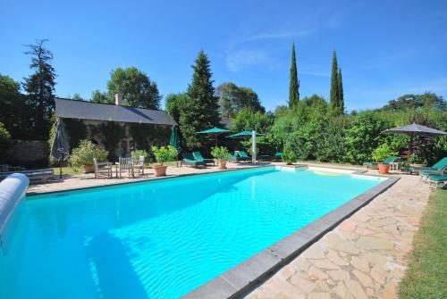 una piscina de agua azul en un patio en Château Des Briottieres, en Champigné