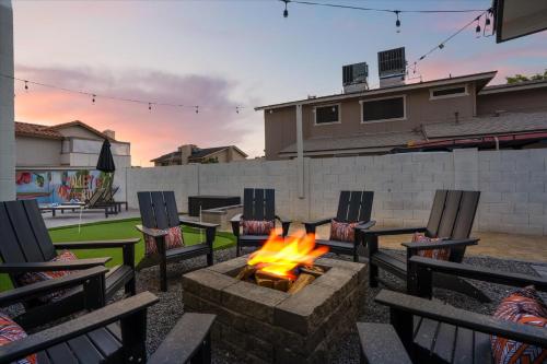 a fire pit in a backyard with chairs and a fire pit at Rock Climbing Wall Pool& Mini Golf Game Room Mural in Peoria