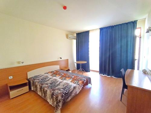 une chambre avec un lit et une table dedans dans l'établissement Central Avenue apartments, à Sunny Beach