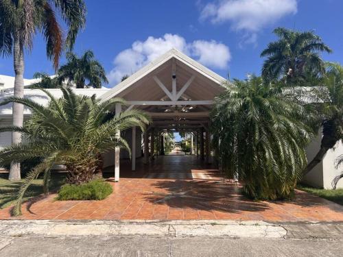 a building with palm trees in front of it at Charmant en bord de plage in Anse Marcel 