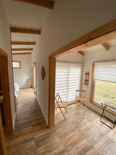 a living room with a large window and wooden floors at Cabañas El jardín de Jacinta in Coihaique