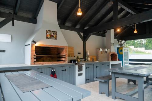 een keuken met blauwe kasten, een tafel en een fornuis bij Hidden Chalet in Tarcău-Gheuca