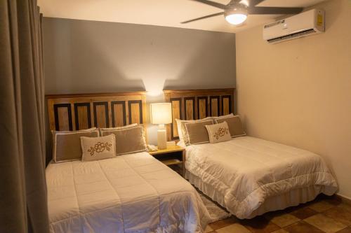 a bedroom with two beds and a table with a lamp at Hotel Cubitá Boutique Resort & Spa in Chitré