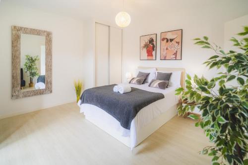 a white bedroom with a bed and a mirror at Fernandes House in Machico