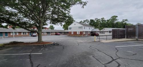 a parking lot with a tree and a building at Town & Country Inn in Seekonk