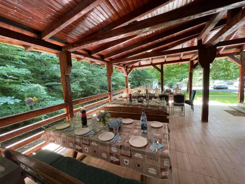 an outdoor dining area of a house with tables and chairs at Cabana de lângă Vale in Budureasa