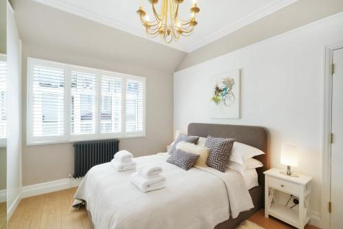 a bedroom with a bed with towels on it at Hidden Gem in Finchley