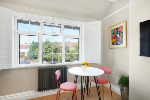 a room with a table and chairs and a window at Hidden Gem in Finchley