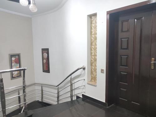a stairway with a wooden door and a stair case at Fully Serviced Holiday Homes Near Emporium Mall & Expo Center in Lahore