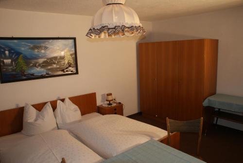 ザウテンスにあるFerienhaus Waldesruhのベッドルーム1室(ベッド2台、シャンデリア付)