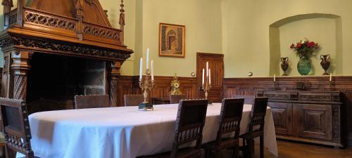 a dining room with a table and a fireplace at Château de Longevergne in Anglards-de-Salers