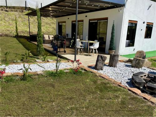 a patio with a table and chairs in a yard at Casa campestre descanso relajación jacuzzi BBQ amplias zonas verdes in Carmen de Viboral