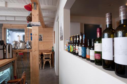 a row of wine bottles on a shelf in a kitchen at Tungulending Guesthouse in Tungulending