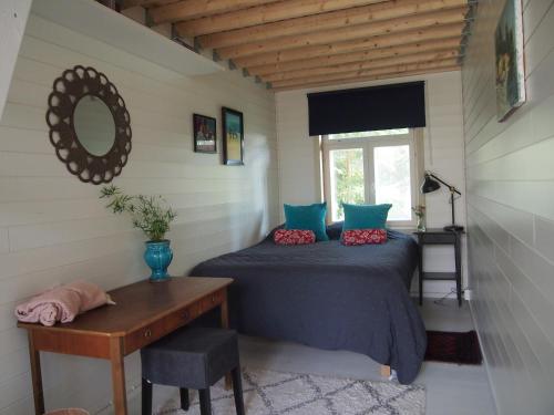 a bedroom with a bed and a table and a mirror at Söderstrand B&B Tammi Room in Suur Ahvenkoski