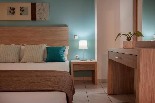 a bedroom with a bed and a table with a plant at Minos Apartments & Studios in Sitia