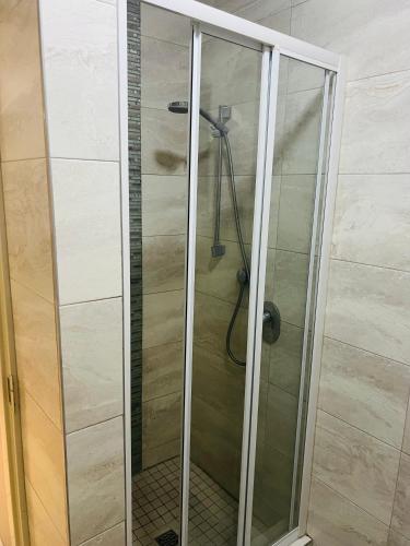 a shower with a glass door in a bathroom at Villa Kristine 3 in Windhoek