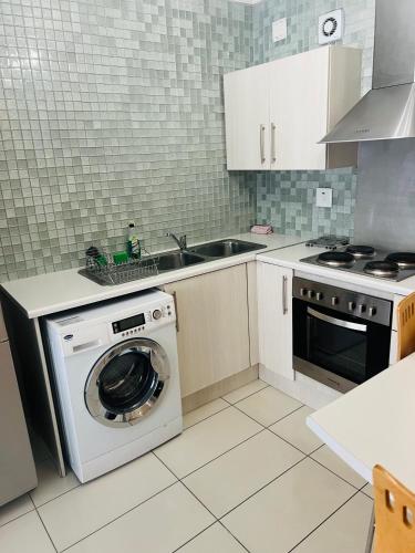 a kitchen with a washing machine and a sink at Villa Kristine 3 in Windhoek