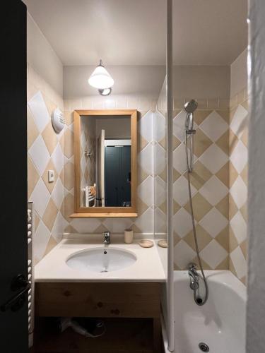 une salle de bain avec un lavabo, un miroir et une baignoire dans l'établissement Résidence La Marelle et Le Rami - maeva Home - Appartement 2 pièces 4 personnes - Sélection MAE-5721, à La Plagne Tarentaise