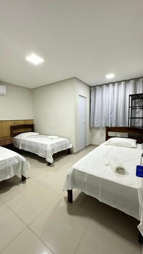 a room with two beds in it with a window at Hotel Brisas in Bom Jesus da Lapa