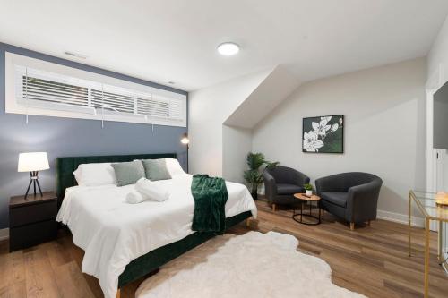 een slaapkamer met een groot bed en twee stoelen bij 2 Bed & 3 Bath Chicago Condo in Chicago