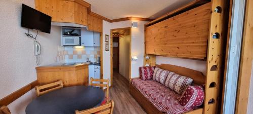une petite maison avec une table et un canapé dans l'établissement Résidence Zenith - Studio pour 4 Personnes 104, à Aime La Plagne